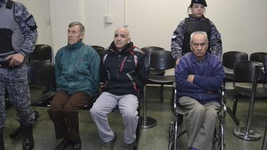 En esta imagen difundida por el Poder Judicial de Mendoza, el cura Horacio Corbacho, con chaqueta verde, el laico Armando Gómez, en el centro, y el sacerdote Nicola Corradi, en silla de ruedas, se sientan en una sala del tribunal antes de un juicio en su contra en Mendoza.&nbsp;