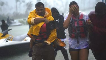 Una familia es escoltada a una zona segura después de ser rescatados tras el paso del huracán Dorian en Freeport, Bahamas, el martes 3 de septiembre de 2019.&nbsp;