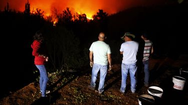 Pobladores observan el avance del fuego en la localidad de Vichuquen región del Maule, a unos 290 km al sur de Santiago.