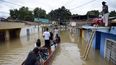 Habitantes navegan por una calle luego de una inundación el pasado sábado. 