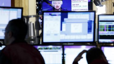 Una pantalla muestra una imagen de la presidenta de la Reserva Federal estadounidense, Janet Yellen, mientras varios agentes de Bolsa realizan su trabajo en el parqué de Nueva York, Estados Unidos.