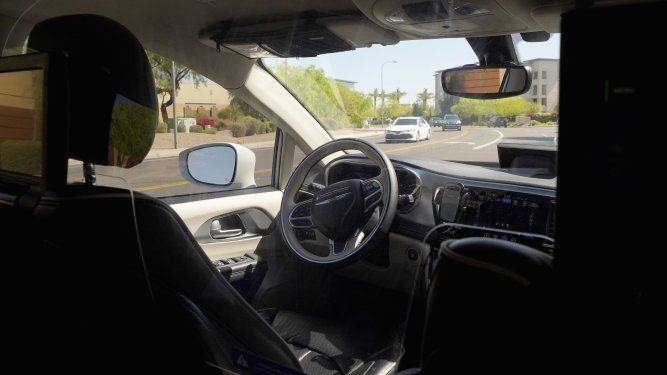Una camioneta de Waymo se mueve por una calle con el asiento del conductor vacío, en un trayecto de vehículo autónomo con pasajeros el 7 de abril de 2021 en Chandler, Arizona. La agencia de seguridad de autopistas de Estados Unidos abrió otra investigación sobre sistemas de conducción automática, esta vez por choques que implicaban a vehículos autónomos Waymo.&nbsp;