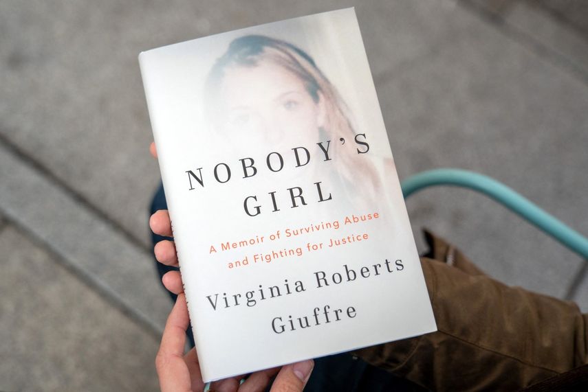 Una persona posa para una foto con un ejemplar del libro Nobodys Girl - A Memoir of Surviving Abuse and Fighting for Justice de Virginia Roberts Giuffre, en el centro de Londres el 21 de octubre de 2025, el día de su lanzamiento en el Reino Unido.