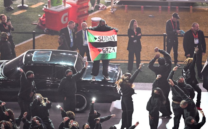 Un manifestante sostiene una bandera palestina con las palabras 'Gaza' y 'Sudán' mientras el rapero estadounidense Kendrick Lamar actúa durante el espectáculo de medio tiempo del Super Bowl LIX entre Chiefs vs Eagles en el Caesars Superdome de Nueva Orleans, Luisiana, el 9 de febrero de 2025.