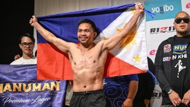 La leyenda del boxeo Manny Pacquiao posa con la bandera de Filipinas en Tokio, el 27 de julio de 2024.