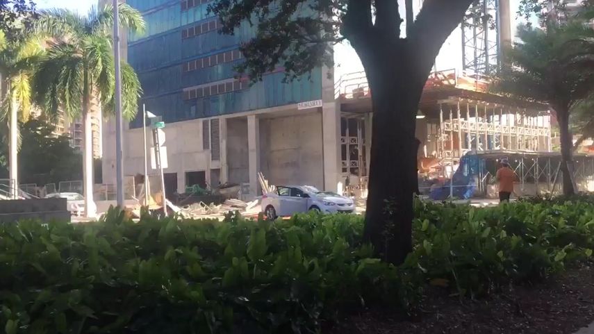 Vista de un auto dañado por la caída de un andamio de un edificio en construcción en Brickell, Miami.