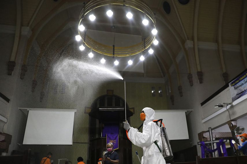 Un operario de la Agencia de Mitigaci&oacute;n de Desastres roc&iacute;a desinfectante dentro de una iglesia por temor a la expansi&oacute;n del nuevo coronavirus, en Surabaya, Java Oriental, Indonesia, el 18 de marzo de 2020.&nbsp;