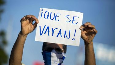 Ciudadano levanta un cartel en contra del gobierno de Daniel Ortega. 