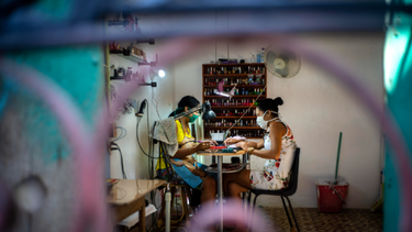 Dos mujeres, equipadas con mascarilla como medida de precaución contra el nuevo coronavirus, en un salón de manicura en una casa en La Habana, Cuba.