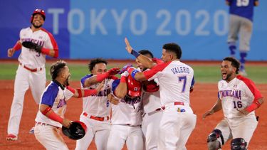 José Bautista (C) de República Dominicana es felicitado por sus compañeros luego de conectar un sencillo impulsor con durante la novena entrada del juego de repechaje de la ronda 1 de béisbol de los Juegos Olímpicos de Tokio 2020
