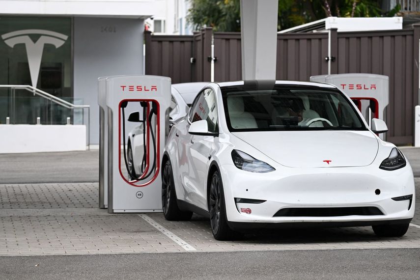 Un auto Tesla recarga sus baterías en una estación.