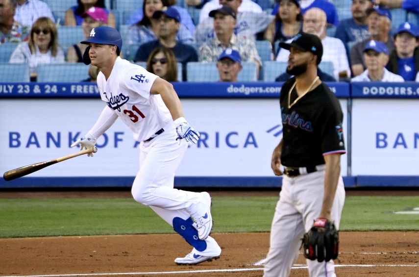 El jugador de los Dodgers de Los Ángeles Joc Pederson, a la izquierda, sale hacia primera base tras pegar un jonrón solitario junto al pitcher abridor de los Marlins de Miami Sandy Alcántara, en el primer inning.