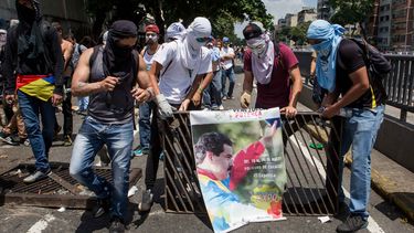 Manifestantes toman un afiche del Presidente Nicolas Maduro para protestar.&nbsp;