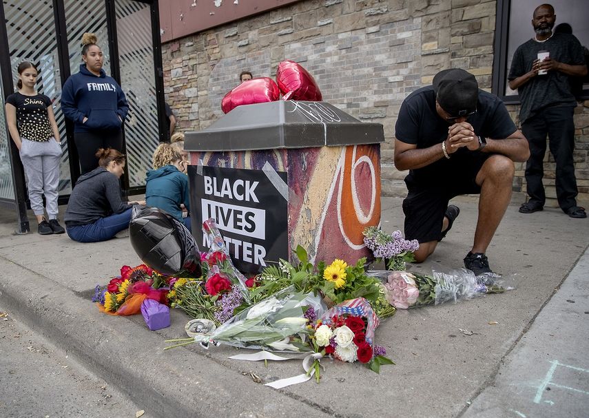 Personas se re&uacute;nen alrededor de un memorial improvisado el martes 26 de mayo de 2020 en Minneapolis, cerca del lugar en donde la polic&iacute;a detuvo un d&iacute;a antes a un hombre negro, quien despu&eacute;s muri&oacute;.&nbsp;