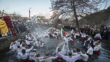 B&uacute;lgaros cantan y bailan en las heladas aguas del r&iacute;o Tundzha durante la festividad religiosa de la Epifan&iacute;a, en Kalofer, Bulgaria, el lunes 6 de enero de 2020.&nbsp;