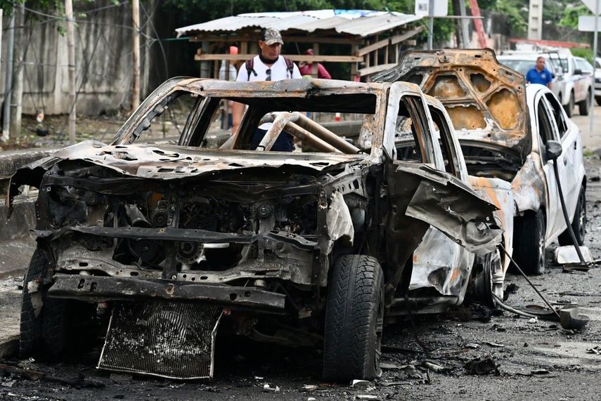 Un hombre camina junto a los restos de un automóvil tras una explosión cerca de la cárcel del Litoral en Guayaquil, Ecuador, el 13 de marzo de 2025. Según las autoridades locales, un guardia de la prisión falleció tras la explosión.&nbsp;