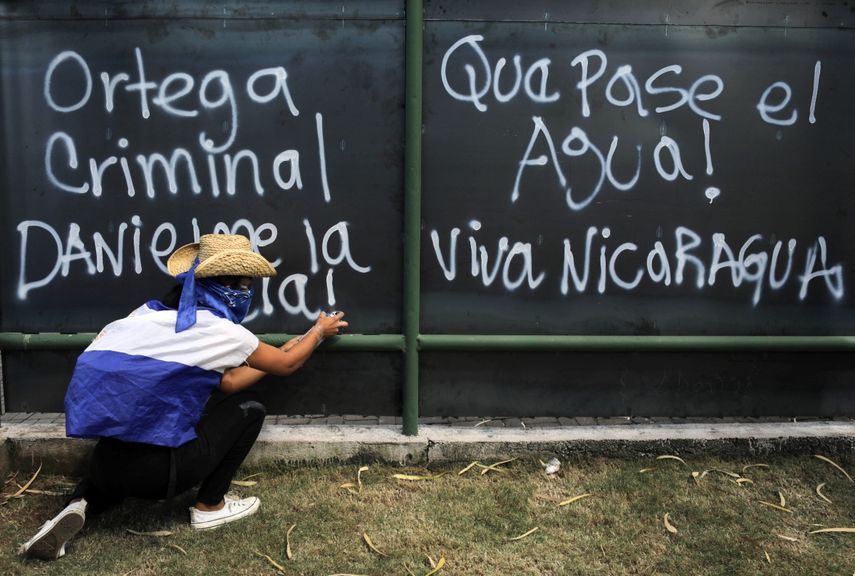 Un estudiante hace un grafiti&nbsp; durante una protesta en el campus de la Universidad Centroamericana (UCA) en apoyo a las madres de presos políticos que están en huelga de hambre en la Iglesia San Miguel de Masay. Managua 22 de noviembre de 2019.