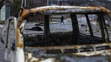 Un hombre camina por una calle con varios cadáveres en el suelo en una calle de Bucha, al noroeste de Kiev, mientras Ucrania dice que las fuerzas rusas están haciendo una retirada rápida de las áreas del norte alrededor de Kiev y la ciudad de Chernigiv, el 2 de abril de 2022.&nbsp; 