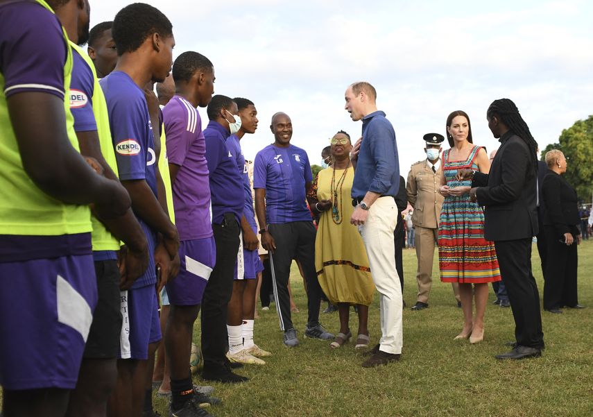 El príncipe William saluda a los jugadores de fútbol de Kingston College, ganadores de la competencia de fútbol ISSA Manning Cup, mientras él y Kate recorren la comunidad de Trench Town en Kingston, Jamaica, el 22 de marzo de 2022.&nbsp;