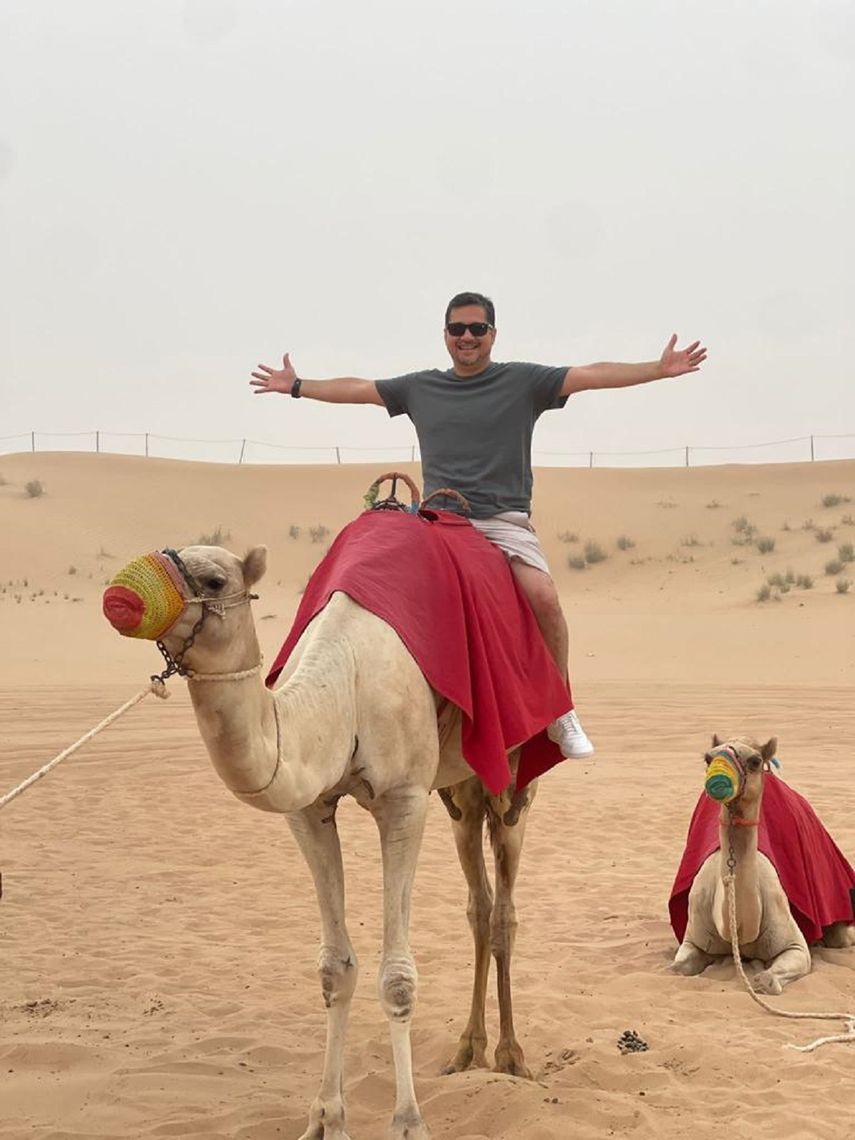 Gian Carlo DAlfonso posa encima de un camello en el desierto.&nbsp;