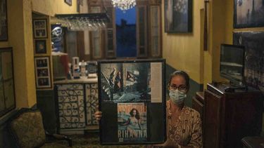 Una trabajadora del restaurante La Guarida posa con fotos de la cantante Rihanna en La Habana, Cuba, el miércoles 3 de noviembre de 2021. 