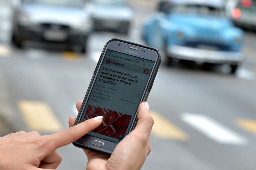 Una mujer usa su teléfono móvil para conectarse a internet mediante wifi en La Habana, el 5 de diciembre de 2018. Los cubanos tendrán la oportunidad de tener internet en sus teléfonos móviles desde el jueves, pero a tarifas más altas.