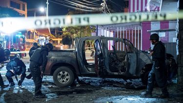 La policía inspecciona una camioneta que explotó afuera de una oficina utilizada por el Servicio Nacional de Atención a Personas Privadas de Libertad que administra el sistema penitenciario en Quito, Ecuador, la madrugada del jueves 31 de agosto de 2023.
