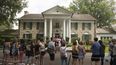 Fans esperan en fila afuera de Graceland el martes, 15 de agosto de 2017, en Memphis, Tennessee.