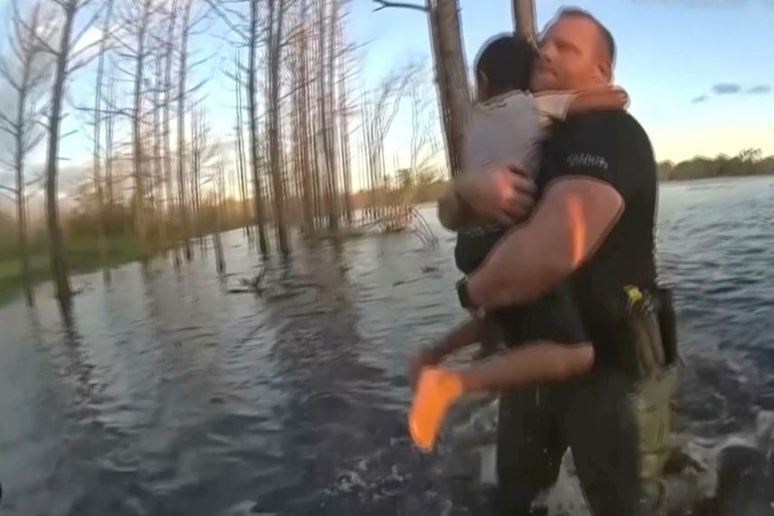En esta imagen extraída de un video grabado con una cámara corporal de un policía del condado Volusia, Florida, el agente Wes Brough salva a un niño autista de 5 años de un estanque en Deltona, Florida.&nbsp; &nbsp;
