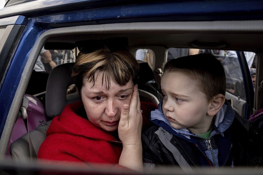 Natalia Pototska, de 43 años, llora ante la mirada de su nieto Matviy en un auto en el centro para personas despkazadas de Zaporiyia, Ucrania, el lunes 2 de mayo de 2022.&nbsp;