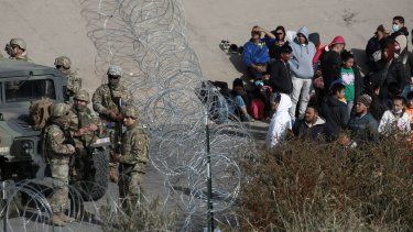 Soldados estadounidenses impiden que migrantes crucen la frontera hacia El Paso, Texas, desde Ciudad Juárez, México, el martes 20 de diciembre de 2022. 