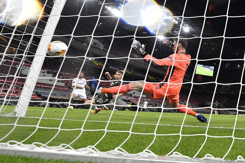 Suso (izquierda) anota el primer gol del Sevilla frente al arquero David de Gea del Manchester United en las semifinales de la Liga Europa, en Colonia, Alemania, el domingo 16 de agosto de 2020.&nbsp;