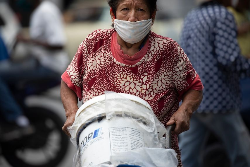 Una mujer, con mascarilla para protegerse del coronavirus, empuja un carrito con recipientes llenos de agua, en Caracas, Venezuela, el 20 de junio de 2020. Se estima que el 86% de los venezolanos reportó problemas con el suministro de agua, incluyendo un 11% que no tiene, según una encuesta realizada por la ONG Observatorio Venezolano de Servicios Públicos entre 4.500 residentes en abril