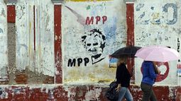 Ciudadanos se dirigen a botar a sus centros bajo la lluvia. Foto AP