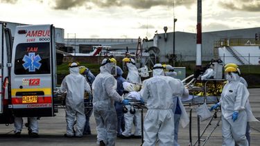Trabajadores de la salud trasladan desde un avi&oacute;n a la ambulancia a personas heridas en una explosi&oacute;n. Un avi&oacute;n de la Fuerza A&eacute;rea de Colombia los transport&oacute; desde el norte de Colombia a Bogot&aacute;, el 8 de julio de 2020.