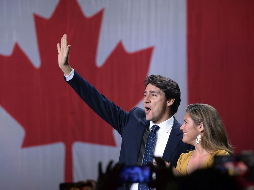 El l&iacute;der del Partido Liberal, Justin Trudeau, y su esposa, Sophie Gregoire Trudeau, saludan sobre el escenario tras conocer los resultados de las elecciones, en la sede de la formaci&oacute;n, en Montreal, el 21 de octubre de 2019.&nbsp;