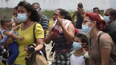 Los migrantes venezolanos lloran después de que fueron detenidos para ser devueltos a Ecuador, en Tumbes, Perú, el sábado 30 de enero de 2021.&nbsp; 