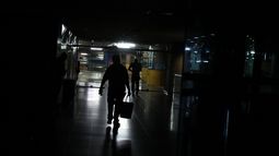 Varias personas caminan a oscuras por una estación del Metro durante un nuevo apagón que dejó sin electricidad este 29 de marzo a buena parte de Caracas y cerca de una decena de los 23 estados del país.