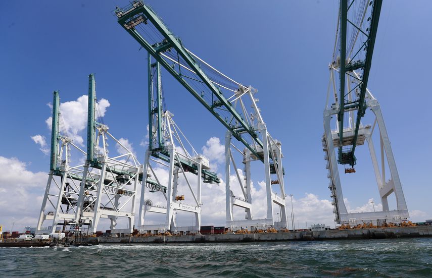 En esta imagen de julio de 2019, enormes grúas descargan contenedores en PortMiami en Miami.
