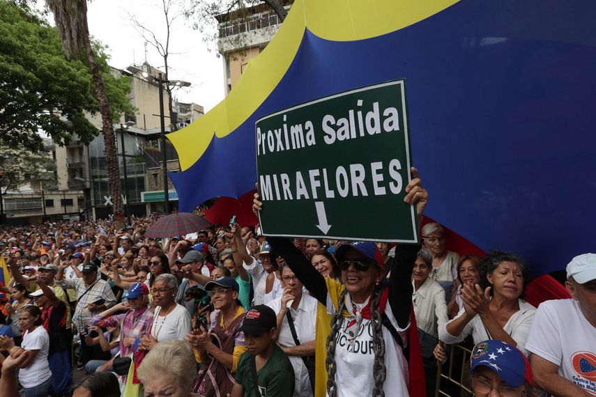 Una mujer sostiene un cartel que invita a una marcha hacia Miraflores durante un cabildo abierto en el municipio de Chacao, en Caracas, donde el presidente encargado de Venezuela, Juan Guaidó, anunció nuevas acciones en su lucha por el cese de la usurpación del poder por Nicolás Maduro.&nbsp;