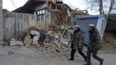 Residentes caminan el miércoles 20 de diciembre de 2023 frente a una vivienda colapsada tras un sismo en la localidad de Yangwa, en la provincia de Gansú, China.&nbsp;