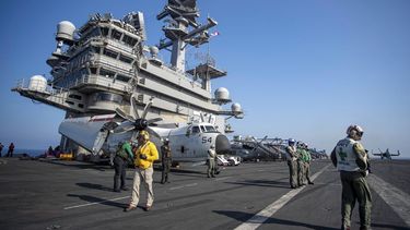 Miembros de la cubierta de vuelo caminan junto a aviones a bordo del portaviones GW Bush mientras navega por el mar Mediterráneo. El portaviones y sus 90 aviones de ataque estarán bajo el mando de la OTAN apoyando a varios grupos de combate, algunos de ellos establecidos como respuesta a la invasión rusa a Ucrania.