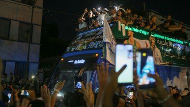 Imane Khelif, campeona olímpica de boxeo, saluda a la multitud desde un autobús al desfilar por Tiaret, Argelia, el viernes 16 de agosto de 2024. 