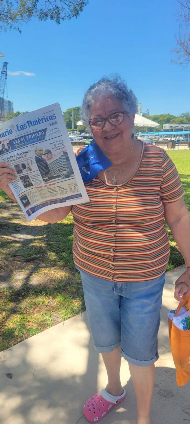 Una señora que participa en el evento 25 aniversario de Miami River Day 2024&nbsp;posa con la edición impresa de Diario Las Américas.