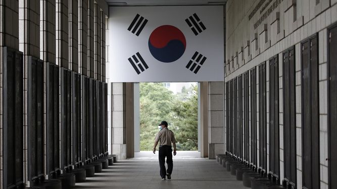Un hombre, con mascarilla para protegerse del nuevo coronavirus, camina por entre los nombres de los soldados estadounidenses y de la ONU muertos en la Guerra de Corea, en el memorial de la Guerra de Corea, en Se&uacute;l, el 25 de junio de 2020.&nbsp;