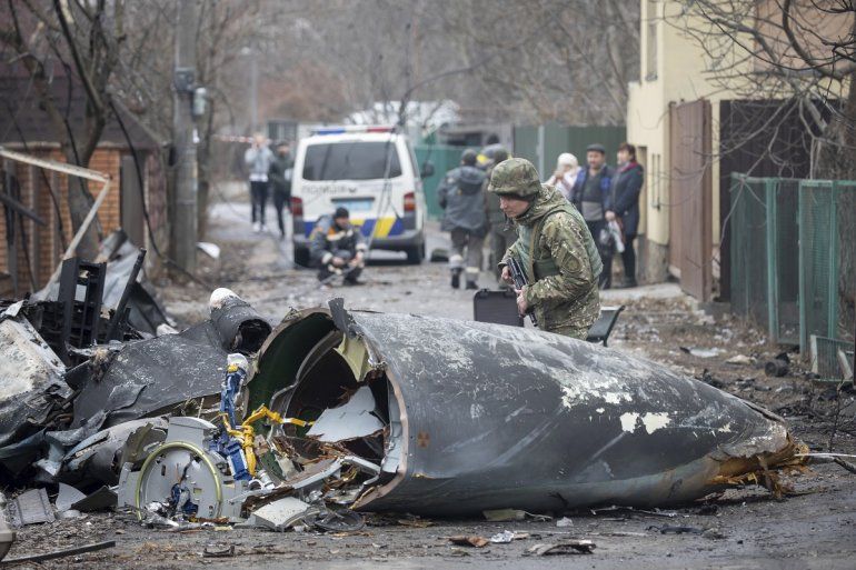 Un soldado ucraniano inspecciona los restos de un avión derribado en Kiev, Ucrania, viernes 25 de febrero de 2022. 