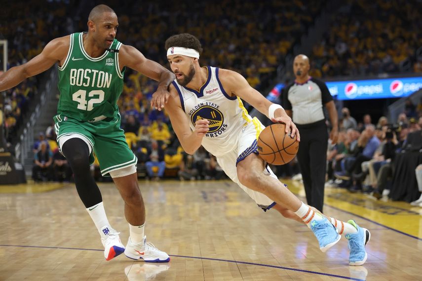 El dominicano Al Horford (42), de los Celtics de Boston, intenta obstruir el avance de Klay Thompson (11), de los Warriors de Golden State, en la segunda mitad del primer partido de las finales de la NBA disputado en San Francisco, el jueves 2 de junio de 2022.