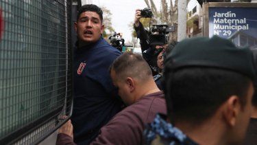Un hincha de la Universidad de Chile detenido es trasladado por la Policía de la Provincia de Buenos Aires desde una comisaría en Avellaneda, provincia de Buenos Aires, Argentina, el 21 de agosto de 2025. Unas 20 personas resultaron heridas y más de 100 fueron detenidas, informaron las autoridades el jueves, tras la suspensión de un partido de la Copa Sudamericana en Buenos Aires entre Independiente y la Universidad de Chile, que se jugó de visitante, tras la violencia sostenida de la multitud.&nbsp;