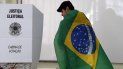 Un hombre envuelto en una bandera brasileña se prepara para emitir su voto durante las elecciones legislativas y presidenciales en Sao Paulo, Brasil, el 2 de octubre de 2022.   