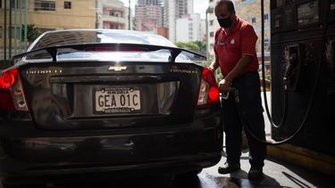 Un trabajador llena el tanque de un vehículo en una gasolinera de Caracas el 5 de octubre de 2020, en medio de la nueva pandemia de coronavirus. Venezuela lanzó este lunes un plan para distribuir gasolina según los números de matrícula de los vehículos, una medida en respuesta a la severa escasez de combustible en el país caribeño.